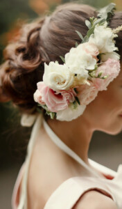 wedding hair style. luxury pink floral wreath on bride hair in tender rich dress at garden. stylish look